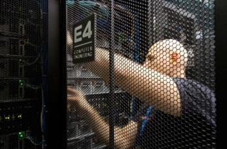 Un tecnico lavora in un data center su un rack con il logo di E4 Computer Engineering