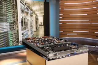 Un server con Maia 300 e, sullo sfondo, dei rack che ospitano ciascuno 24 server Un server con Maia 300 e, sullo sfondo, dei rack che ospitano ciascuno 24 server